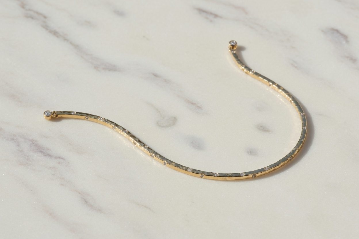 A slim diamond line bracelet on pale marble.